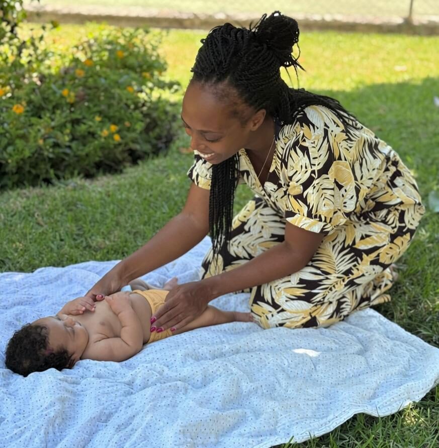 Nath massaging a baby outdoors
